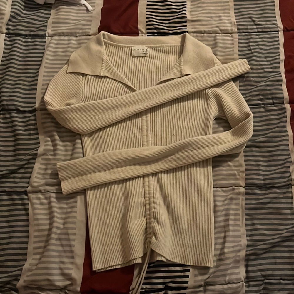 A cream long sleeve crop top with drawstrings